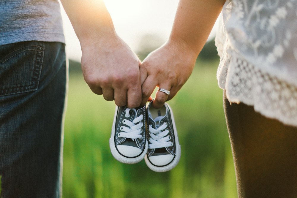 Aanstaande ouders houden babyschoentjes vast